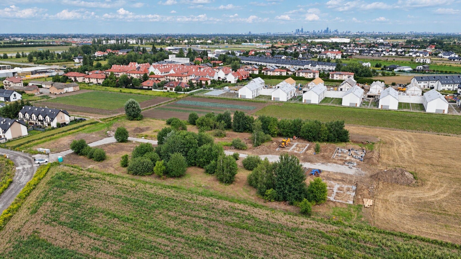 Widok z drona na teren budowy osiedla Ostoja Hortensji z panoramą okolicy